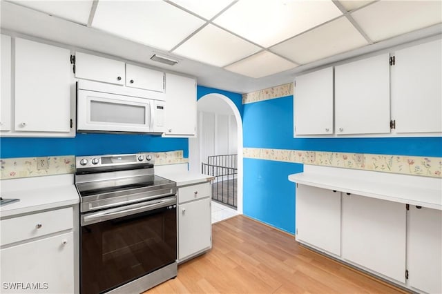 2330 Caladium Rd, Fort Myers, FL 33905 - kitchen featuring stainless steel electric range oven, white microwave, light countertops, light wood-style floors, and a paneled ceiling