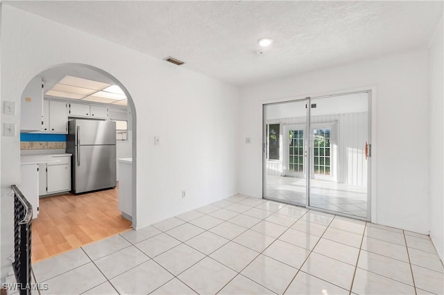 2330 Caladium Rd, Fort Myers, FL 33905 - unfurnished room featuring arched walkways, light tile patterned floors, and a textured ceiling