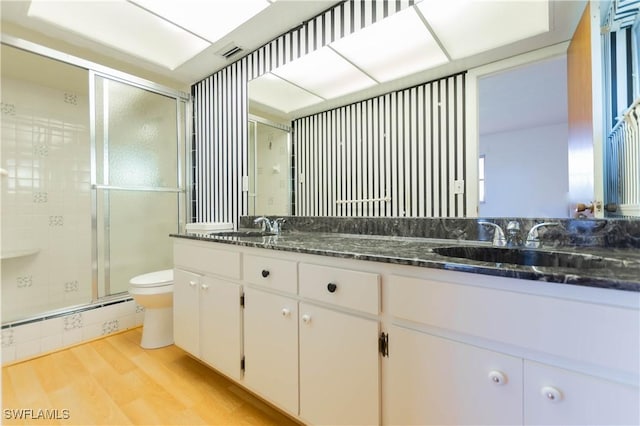 2330 Caladium Rd, Fort Myers, FL 33905 - bathroom featuring double vanity, baseboard heating, a shower stall, and wood finished floors