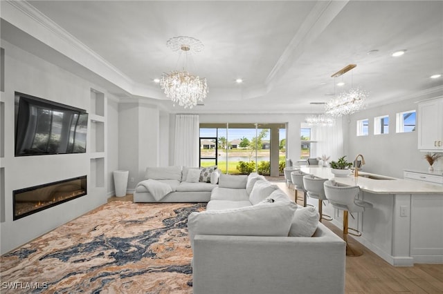 28041 Captiva Shell Loop, Bonita Springs, FL 34135 - living room with a chandelier, ornamental molding, light wood-type flooring, a glass covered fireplace, and recessed lighting