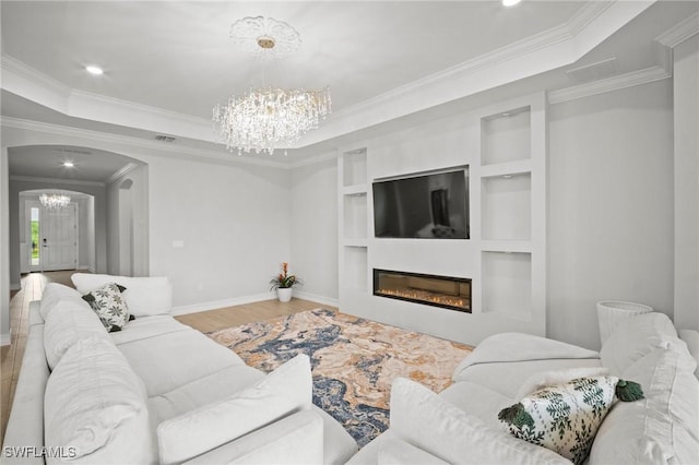 28041 Captiva Shell Loop, Bonita Springs, FL 34135 - living area with a chandelier, ornamental molding, arched walkways, wood finished floors, and a glass covered fireplace