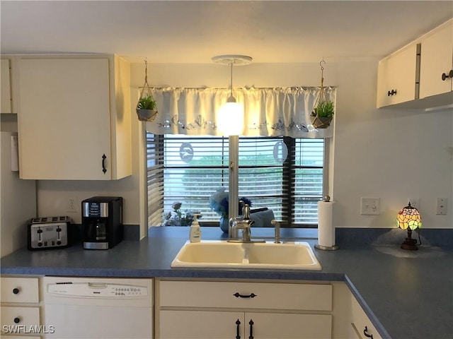 18437 Orangecrest Ct, Lehigh Acres, FL 33936 - kitchen featuring white dishwasher, a sink, dark countertops, and white cabinetry