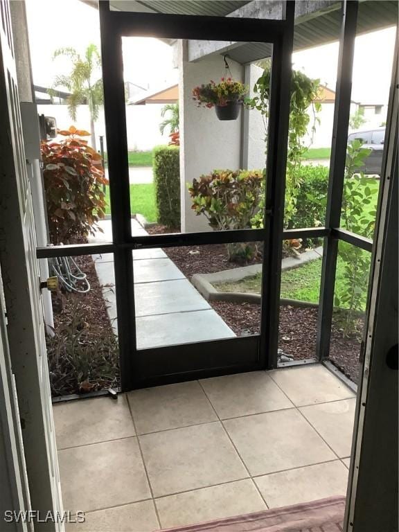 18437 Orangecrest Ct, Lehigh Acres, FL 33936 - doorway featuring tile patterned floors and plenty of natural light