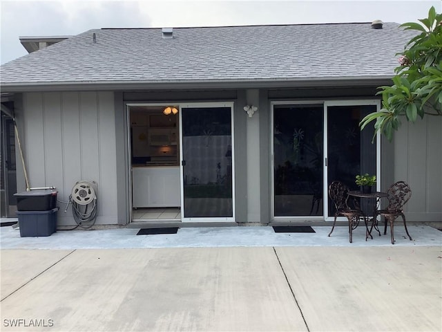 18437 Orangecrest Ct, Lehigh Acres, FL 33936 - property entrance featuring roof with shingles, a patio, and board and batten siding