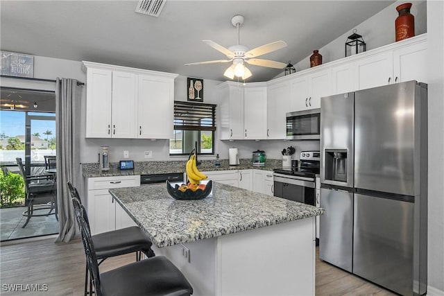325 NE 24th Ter, Cape Coral, FL 33909 - kitchen featuring stainless steel appliances, a ceiling fan, light wood-style floors, white cabinets, and light stone countertops