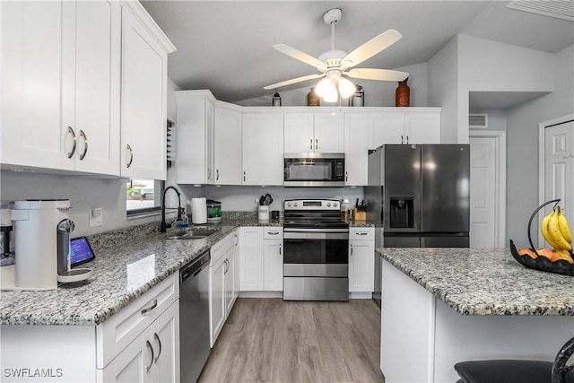 325 NE 24th Ter, Cape Coral, FL 33909 - kitchen featuring stainless steel appliances, a sink, a ceiling fan, and white cabinetry