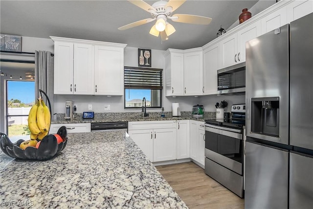 325 NE 24th Ter, Cape Coral, FL 33909 - kitchen featuring stainless steel appliances, a ceiling fan, white cabinetry, and healthy amount of natural light