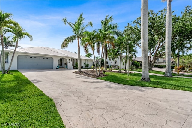 5630 Riverside Dr, Cape Coral, FL 33904 - view of front of house with driveway, an attached garage, stucco siding, and a front lawn