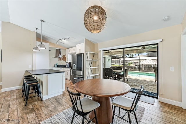 5630 Riverside Dr, Cape Coral, FL 33904 - dining space with light wood-style flooring, a sunroom, vaulted ceiling, baseboards, and ceiling fan
