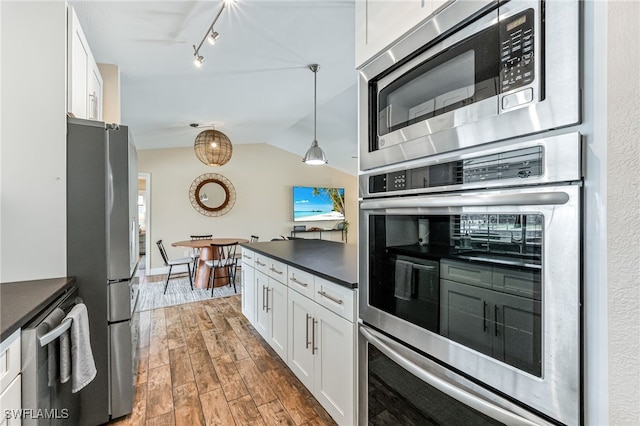 5630 Riverside Dr, Cape Coral, FL 33904 - kitchen with appliances with stainless steel finishes, dark countertops, white cabinets, wood finished floors, and lofted ceiling