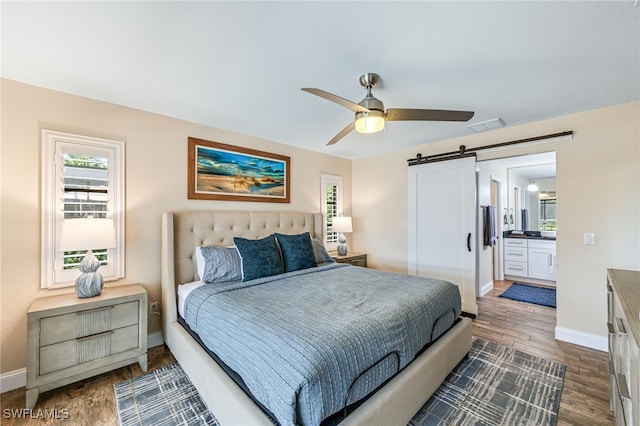 5630 Riverside Dr, Cape Coral, FL 33904 - bedroom with a barn door, baseboards, and dark wood-type flooring