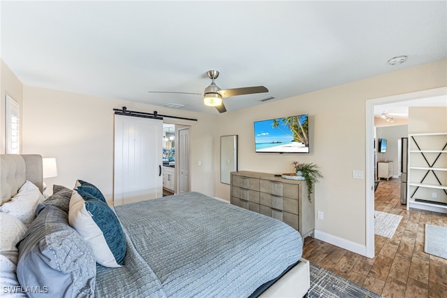5630 Riverside Dr, Cape Coral, FL 33904 - bedroom with a barn door, wood finished floors, baseboards, and ceiling fan