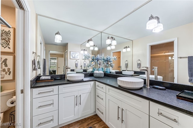 5630 Riverside Dr, Cape Coral, FL 33904 - bathroom with double vanity, toilet, a chandelier, and wood finished floors