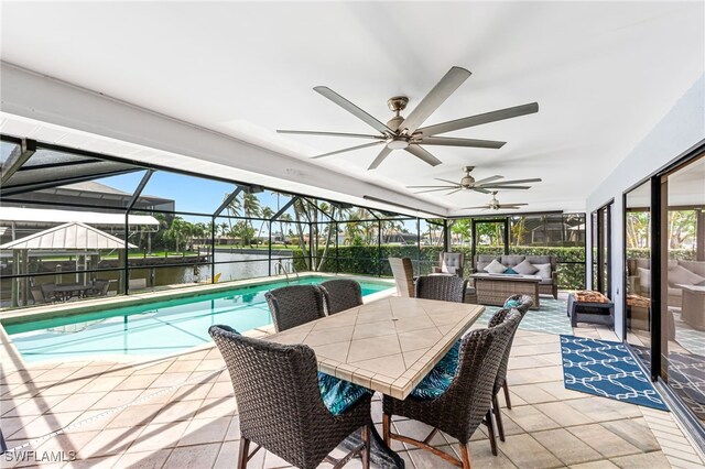 5630 Riverside Dr, Cape Coral, FL 33904 - swimming pool featuring outdoor lounge area, a patio area, a water view, a ceiling fan, and a lanai
