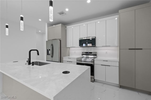 928 NE 8th Place, Cape Coral, FL 33909 - kitchen featuring appliances with stainless steel finishes, a sink, light marble finish flooring, recessed lighting, and modern cabinets