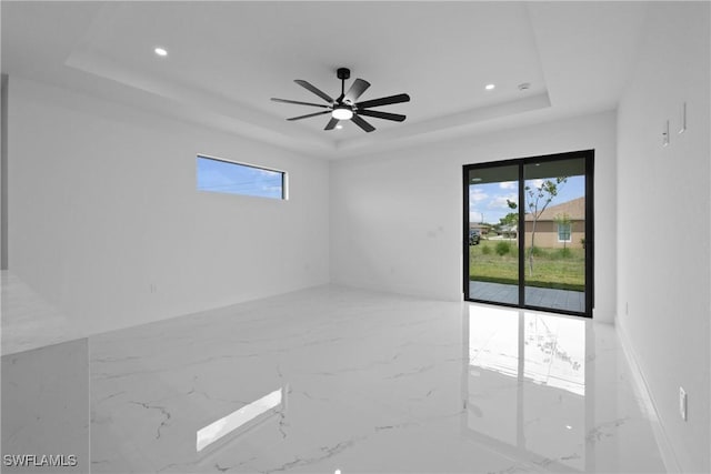 928 NE 8th Place, Cape Coral, FL 33909 - unfurnished room with a tray ceiling, marble tiled flooring, healthy amount of natural light, and recessed lighting