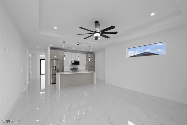 928 NE 8th Place, Cape Coral, FL 33909 - unfurnished living room featuring a raised ceiling, recessed lighting, a ceiling fan, and light marble finish floors