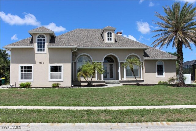4150 Enclave Pl, Punta Gorda, FL 33980 - view of front of home featuring stucco siding, a front yard, french doors, and a shingled roof