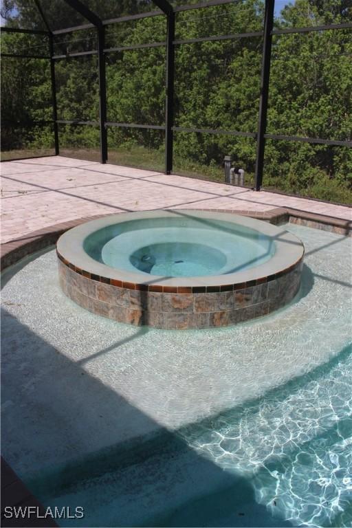 4150 Enclave Pl, Punta Gorda, FL 33980 - view of pool featuring an in-ground hot tub, glass enclosure, and a swimming pool