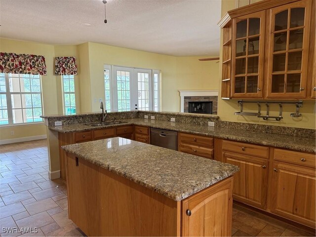 4150 Enclave Pl, Punta Gorda, FL 33980 - kitchen featuring a sink, stainless steel dishwasher, a kitchen island, healthy amount of natural light, and a textured ceiling