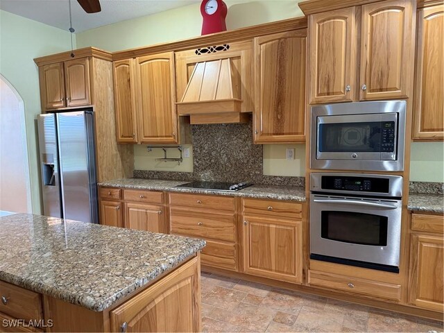 4150 Enclave Pl, Punta Gorda, FL 33980 - kitchen with stainless steel appliances, custom range hood, stone counters, decorative backsplash, and light stone finish flooring