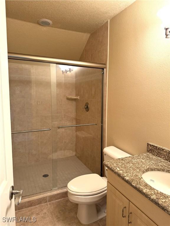 4150 Enclave Pl, Punta Gorda, FL 33980 - bathroom with vanity, a stall shower, toilet, tile patterned flooring, and lofted ceiling