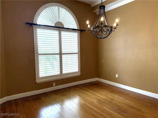 4150 Enclave Pl, Punta Gorda, FL 33980 - empty room featuring healthy amount of natural light, baseboards, wood-type flooring, and a chandelier