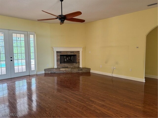 4150 Enclave Pl, Punta Gorda, FL 33980 - unfurnished living room featuring wood finished floors, arched walkways, a ceiling fan, french doors, and baseboards