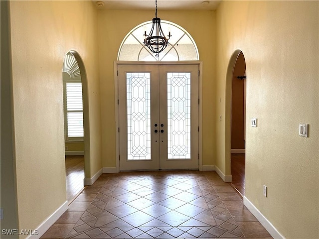 4150 Enclave Pl, Punta Gorda, FL 33980 - tiled foyer with arched walkways, a chandelier, baseboards, french doors, and a high ceiling