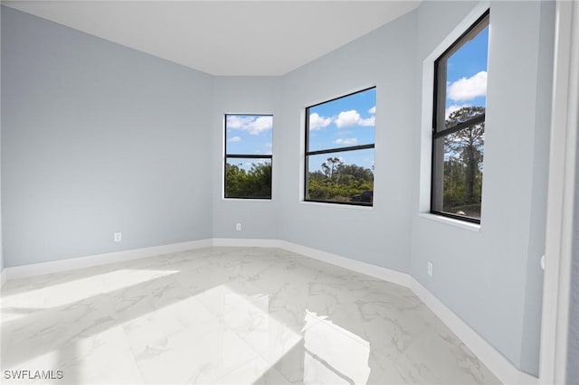 570 Sherwood Ave S, Lehigh Acres, FL 33974 - empty room featuring light marble finish floors and baseboards
