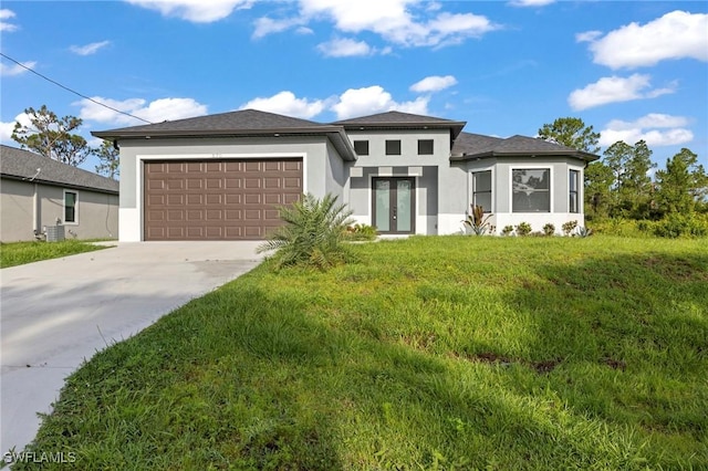 570 Sherwood Ave S, Lehigh Acres, FL 33974 - prairie-style home with french doors, stucco siding, driveway, a garage, and a front lawn