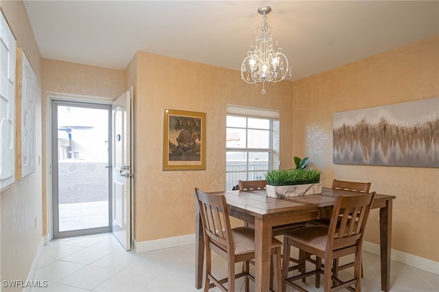 2080 W 1st St Unit 206, Fort Myers, FL 33901 - dining area featuring a chandelier, baseboards, and light tile patterned flooring