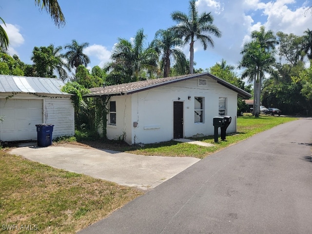 137 Standish Cir, North Fort Myers, FL 33903 - view of front of house with a front lawn, an outbuilding, stucco siding, concrete driveway, and a garage