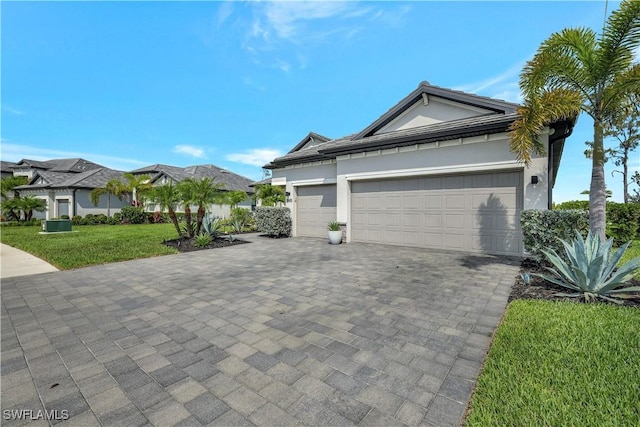 11693 Canopy Loop, Fort Myers, FL 33913 - view of home's exterior with decorative driveway, a lawn, an attached garage, and stucco siding