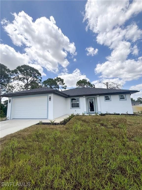 3806 15th St W, Lehigh Acres, FL 33971 - view of front facade featuring concrete driveway, an attached garage, stucco siding, and a front lawn