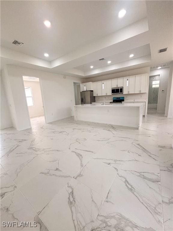 3806 15th St W, Lehigh Acres, FL 33971 - unfurnished living room with a raised ceiling, recessed lighting, a sink, and baseboards