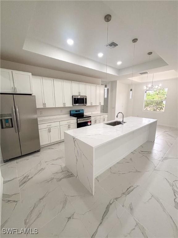 3806 15th St W, Lehigh Acres, FL 33971 - kitchen with stainless steel appliances, a tray ceiling, a sink, white cabinetry, and hanging light fixtures