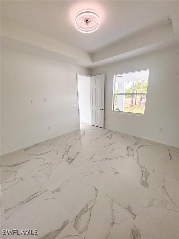 3806 15th St W, Lehigh Acres, FL 33971 - empty room featuring baseboards, marble finish floors, and a smoke detector