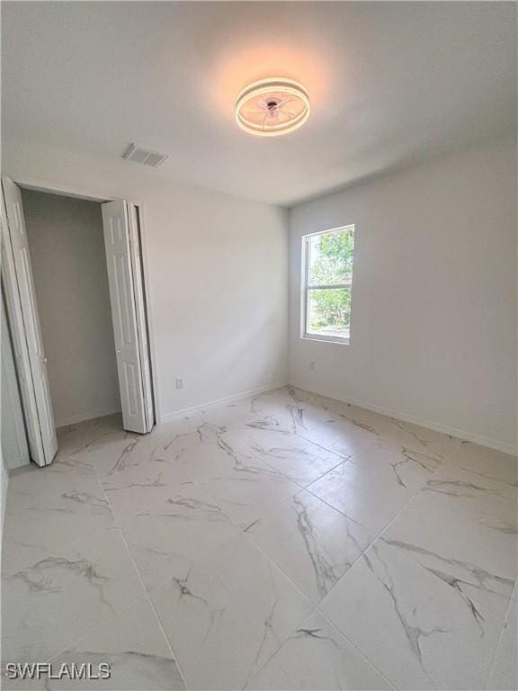 3806 15th St W, Lehigh Acres, FL 33971 - unfurnished bedroom with light marble finish floors, baseboards, and a closet