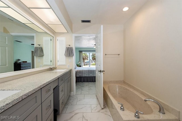 1704 Coral Way N, Fort Myers, FL 33917 - ensuite bathroom with marble look tile flooring, a bath, double vanity, recessed lighting, and a ceiling fan
