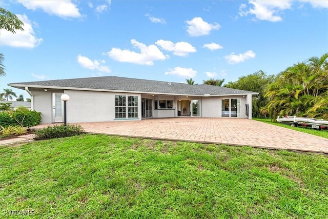 1704 Coral Way N, Fort Myers, FL 33917 - rear view of property featuring a patio, stucco siding, and a lawn