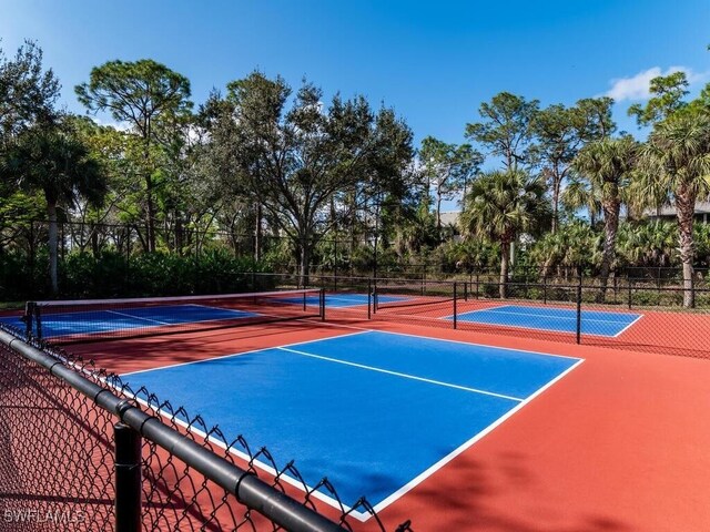 411 Valerie Way Unit 103, Naples, FL 34104 - view of tennis court featuring community basketball court and view of wooded area