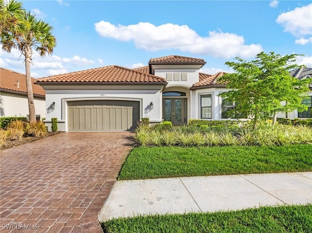 8341 Promoso Ct, Naples, FL 34114 - mediterranean / spanish-style home featuring french doors, a garage, decorative driveway, and stucco siding