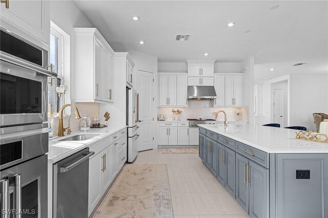 8341 Promoso Ct, Naples, FL 34114 - kitchen featuring appliances with stainless steel finishes, under cabinet range hood, white cabinetry, light countertops, and recessed lighting