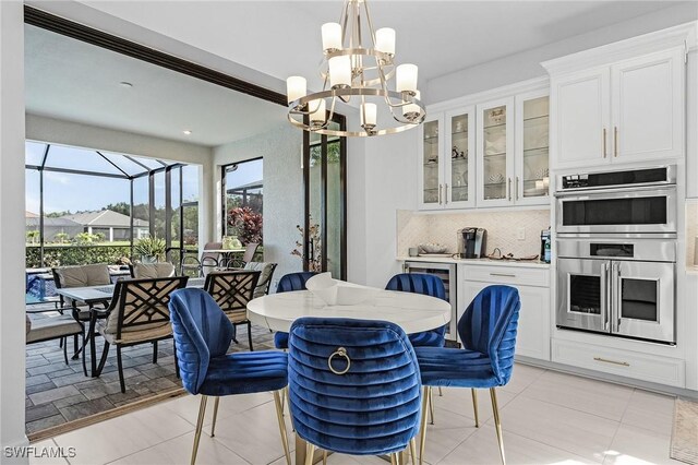 8341 Promoso Ct, Naples, FL 34114 - dining space featuring a chandelier, a sunroom, and light tile patterned floors