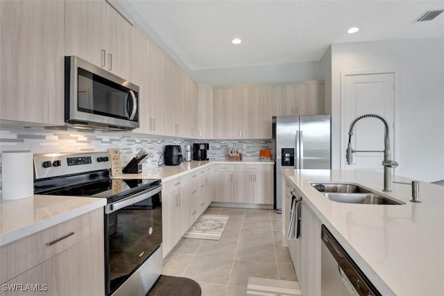 5273 Lamone Ln, Ave Maria, FL 34142 - kitchen featuring stainless steel appliances, a sink, light brown cabinets, modern cabinets, and recessed lighting