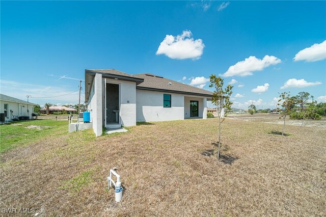 2458 NW 21st Ter, Cape Coral, FL 33993 - rear view of property with stucco siding and a yard