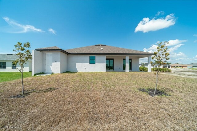 2458 NW 21st Ter, Cape Coral, FL 33993 - back of house with stucco siding and a yard