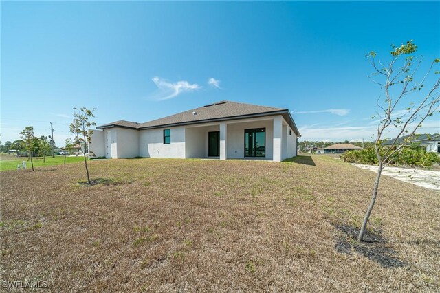 2458 NW 21st Ter, Cape Coral, FL 33993 - back of property featuring a lawn and stucco siding