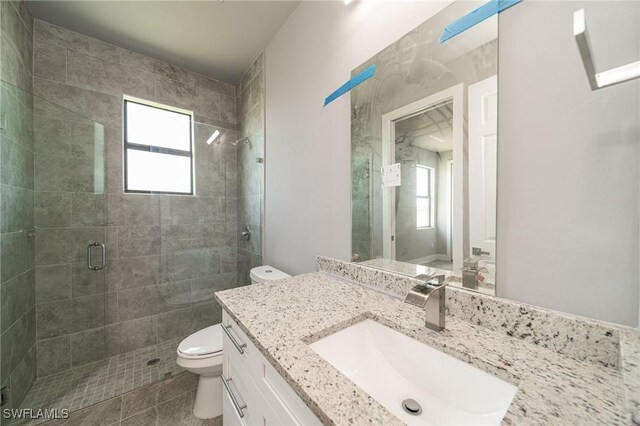 2458 NW 21st Ter, Cape Coral, FL 33993 - bathroom featuring toilet, vanity, and a stall shower